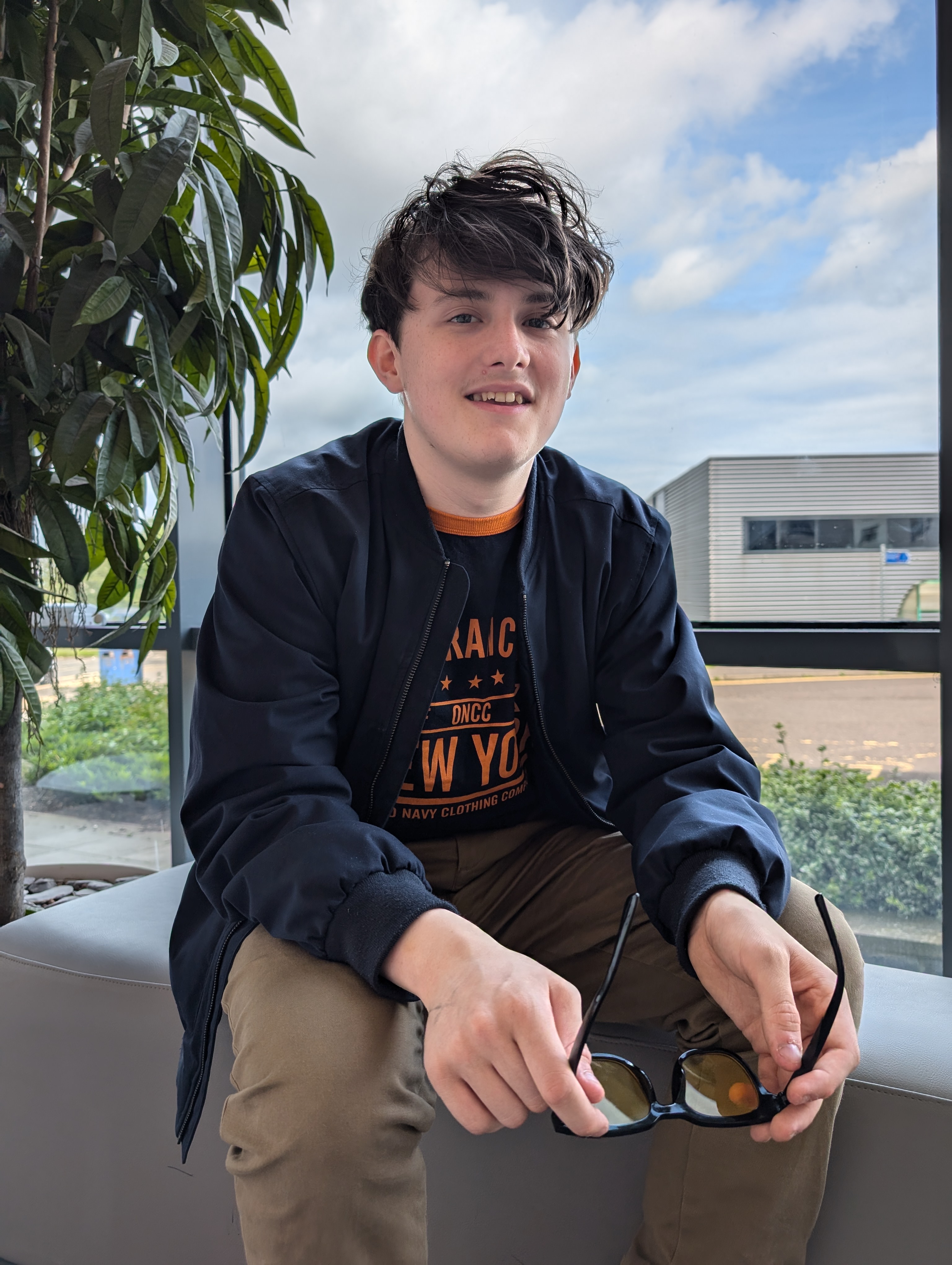 Adam Lowe, President, sitting on a bench in Sighthill Atrium
