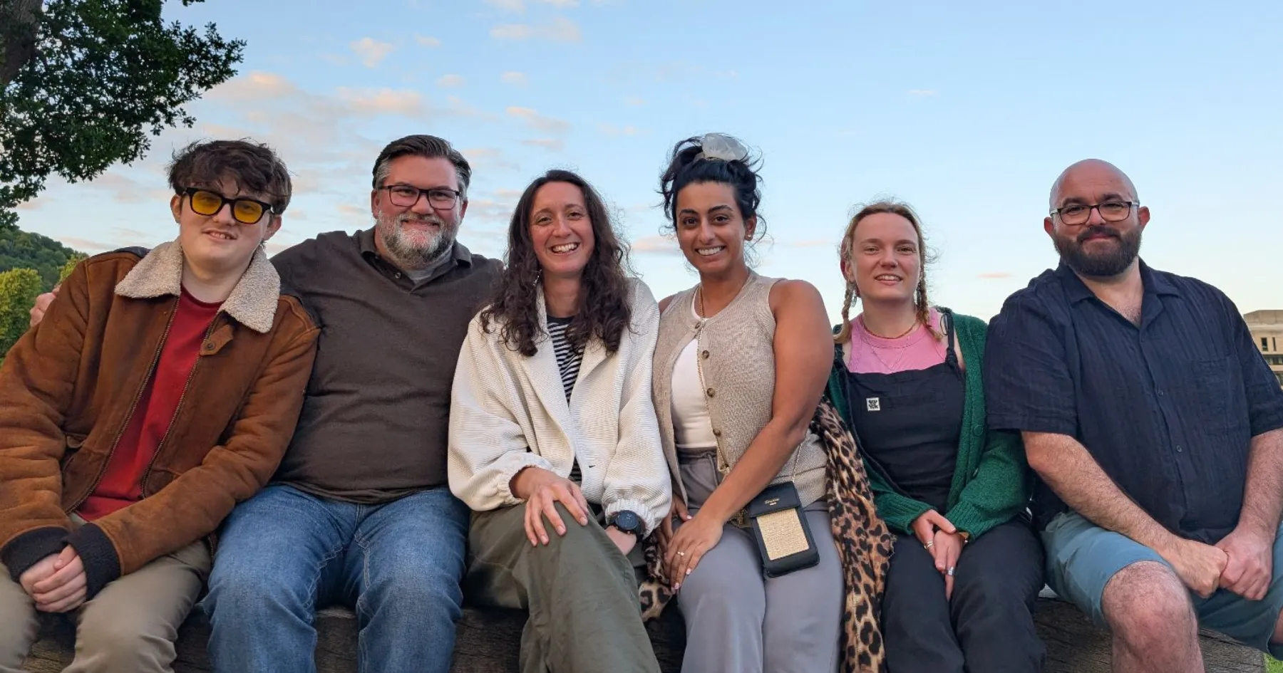 EC Students' Association Team sitting on a bench outside smiling
