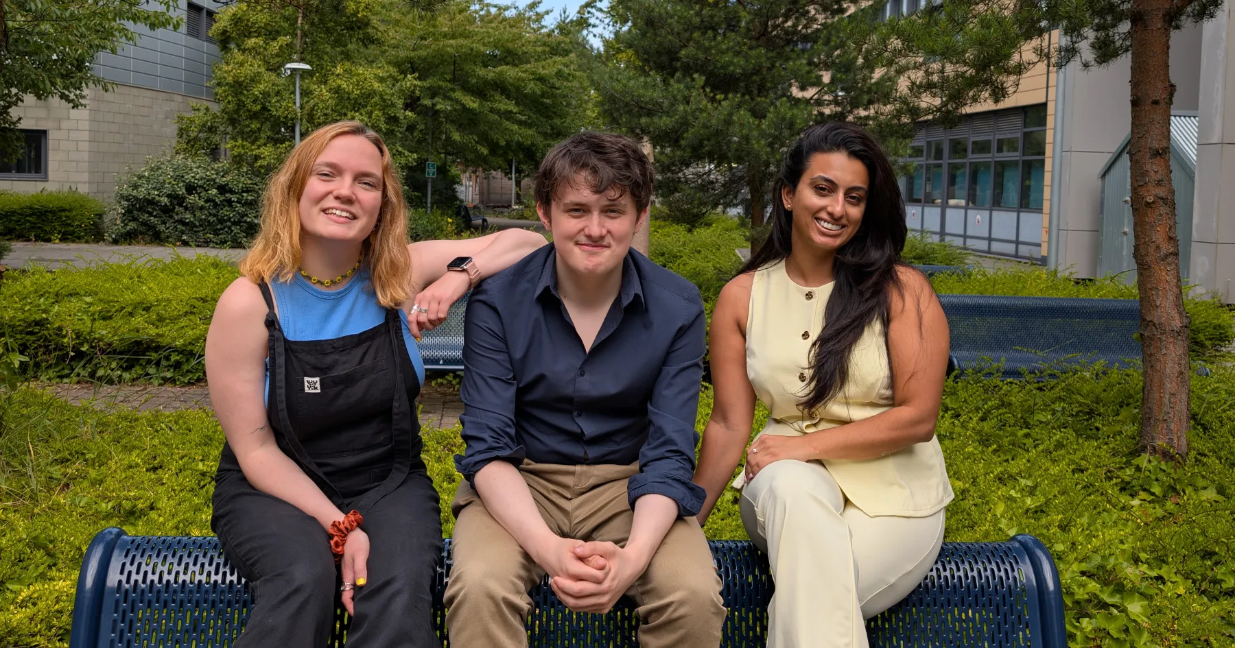 Mary, Adam, and Sukinder sitting on a bench outside in the Granton Quad