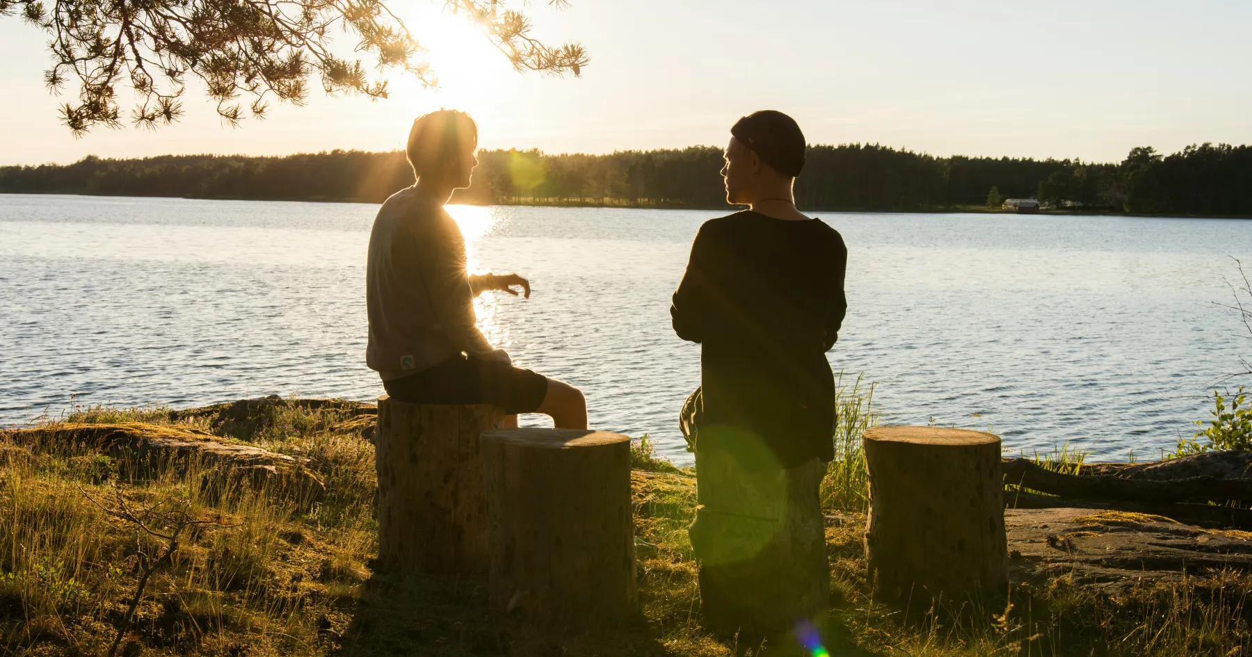 two people sitting by some water chatting