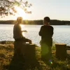 two people sitting by some water chatting